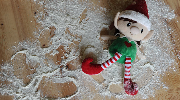 Christmas Elf Making Snow Angels in Flour